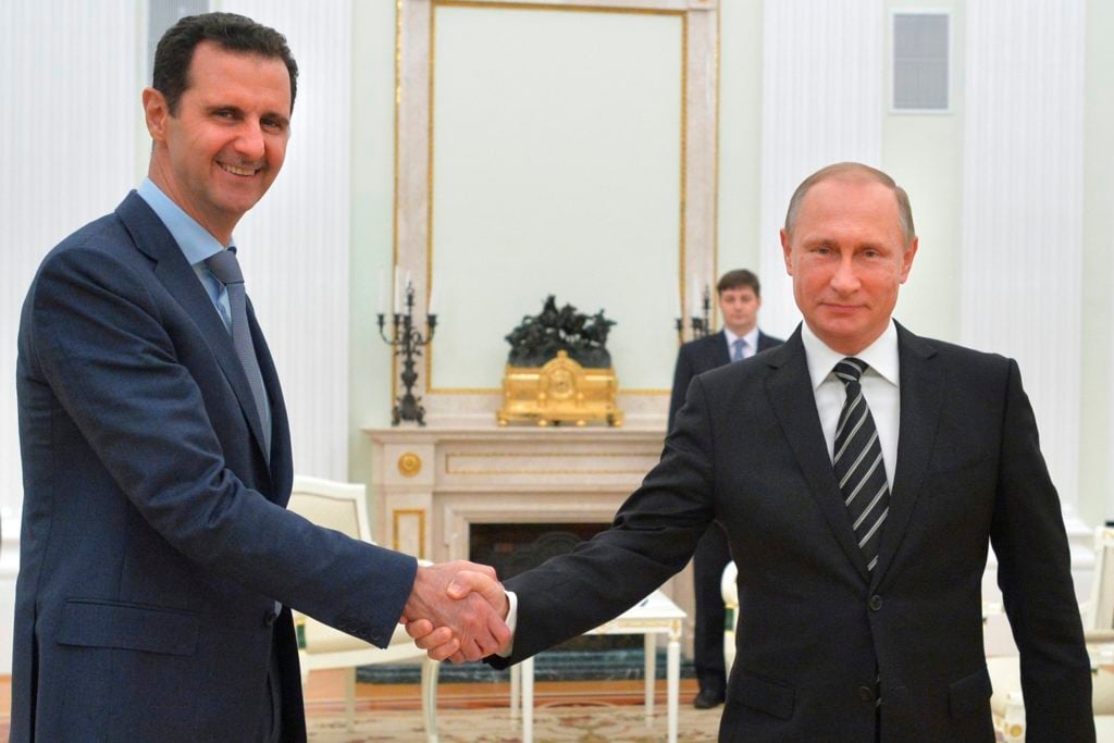 In this photo taken on Tuesday, Oct. 20, 2015, Russian President Vladimir Putin, right, shakes hand with Syria President Bashar Assad in the Kremlin in Moscow, Russia. Assad has traveled to Moscow in his first known trip abroad since the war broke out in Syria in 2011 to meet his strongest ally Russian leader Vladimir Putin, Syrian and Russian media reported Wednesday. (Alexei Druzhinin, RIA-Novosti, Kremlin Pool Photo via AP)