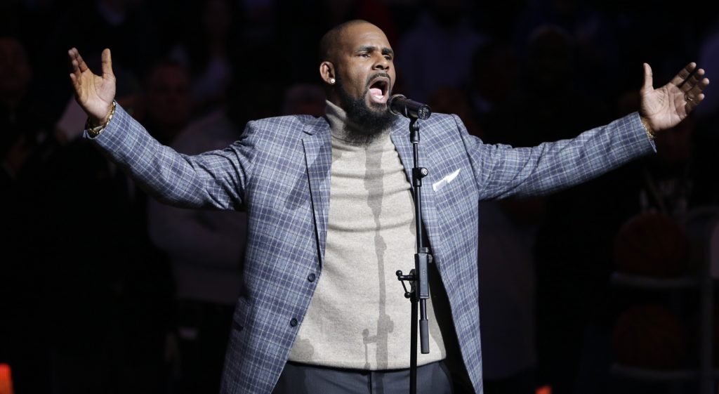 FILE - In this Nov. 17, 2015 file photo. musical artist R. Kelly performs the national anthem before an NBA basketball game between the Brooklyn Nets and the Atlanta Hawks in New York. Officials in a Georgia county want an upcoming concert by R. Kelly canceled after a media report accusing the singer of mental and physical abuse of women. The Fulton County Board of Commissioners this week sent a letter asking Live Nation, the company contracted to book events at a county-owned venue outside Atlanta, to cancel Kelly’s Aug. 25, 2017 concert.(AP Photo/Frank Franklin II)