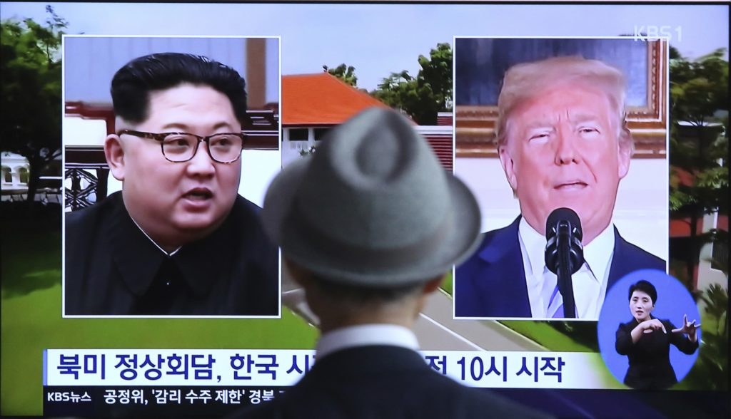 A man watches a TV screen showing file footage of U.S. President Donald Trump, right, and North Korean leader Kim Jong Un during a news program at the Seoul Railway Station in Seoul, South Korea, Monday, June 11, 2018. Final preparations are underway in Singapore for Tuesday's historic summit between President Trump and North Korean leader Kim, including a plan for the leaders to kick things off by meeting with only their translators present, a U.S. official said. The signs read: " Summit between the United States and North Korea." (AP Photo/Ahn Young-joon)