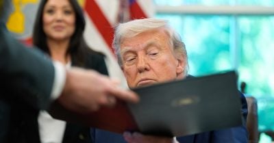 President Donald Trump reviews an executive order at the White House, amid sweeping changes targeting education and civil rights policies.