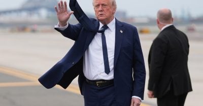 Donald Trump waves on airport tarmac during his second term, as approval ratings fall and controversy grows over economic and civil rights policies
