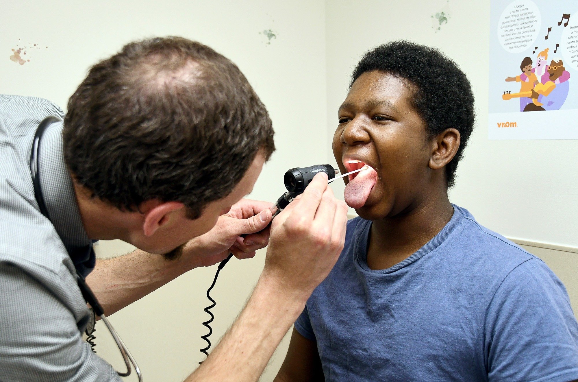 A pediatrician examines a young Black patient during a routine checkup at a community health clinic.