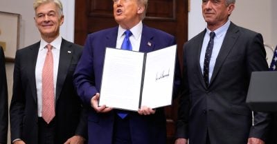 President Donald Trump, with Dr. Mehmet Oz and Robert F. Kennedy Jr., holds an executive order related to drug prices, in the Roosevelt Room of the White House.