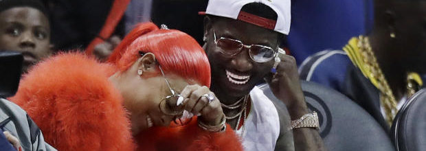Hip Hop artist Gucci Mane, right, laughs with Keyshia Ka'oir after he proposed to her in the fourth quarter of an NBA basketball game between the Atlanta Hawks and the New Orleans Pelicans in Atlanta, Tuesday, Nov. 22, 2016. (AP Photo/David Goldman)