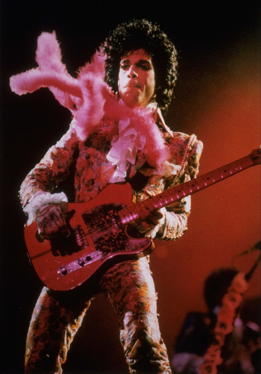 Purple Rain star Prince performs in concert at the Summit Thursday night, Jan. 11, 1985 before a sold-out audience, his first of six Houston shows.  A purple feather boa blows in the wind from a fan. (AP Photo/F. Carter Smith)