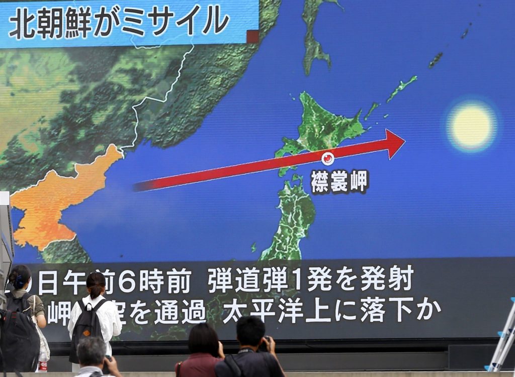 People walk by a TV news program reporting North Korea's missile launch, in Tokyo, Tuesday, Aug. 29, 2017. North Korea fired a ballistic missile from its capital Pyongyang that flew over Japan before plunging into the northern Pacific Ocean, officials said Tuesday, an aggressive test-flight over the territory of a close U.S. ally that sends a clear message of defiance as Washington and Seoul conduct war games nearby.  (AP Photo/Shizuo Kambayashi)