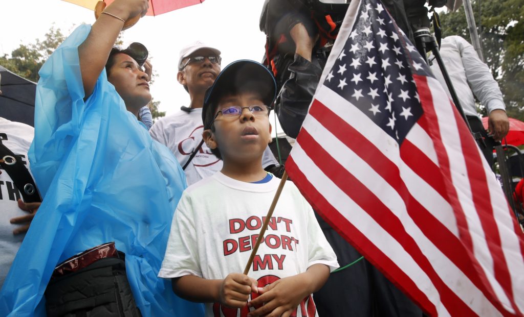 Michael Claros, 8, of Silver Spring, Md., attends a rally in favor of immigration reform, Tuesday, Aug. 15, 2017, at the White House in Washington. The eight-year old is a U.S. citizen whose parents would have been eligible for DAPA, or Deferred Action for Parents of Americans, an Obama era policy memo that the Trump administration has since formally revoked. The protesters are hoping to preserve the program known as Deferred Action for Childhood Arrivals, or DACA. The Trump administration has said it still has not decided the DACA program's fate. (AP Photo/Jacquelyn Martin)