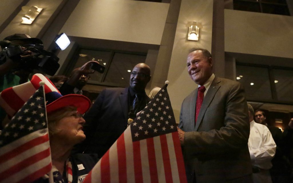 Former Alabama Chief Justice and U.S. Senate candidate Roy Moore, greets supporter Patricia Jones, left, before his election party, Tuesday, Sept. 26, 2017, in Montgomery, Ala. (AP Photo/Brynn Anderson)