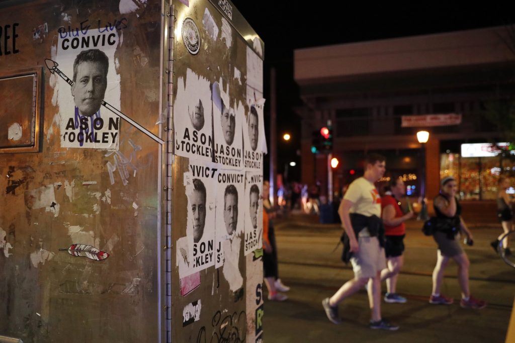 People march past images of former St. Louis police officer Jason Stockley after a not guilty verdict in his trial  Saturday, Sept. 16, 2017, in St. Louis. Stockley was acquitted in the 2011 killing of a black man following a high-speed chase. (AP Photo/Jeff Roberson)