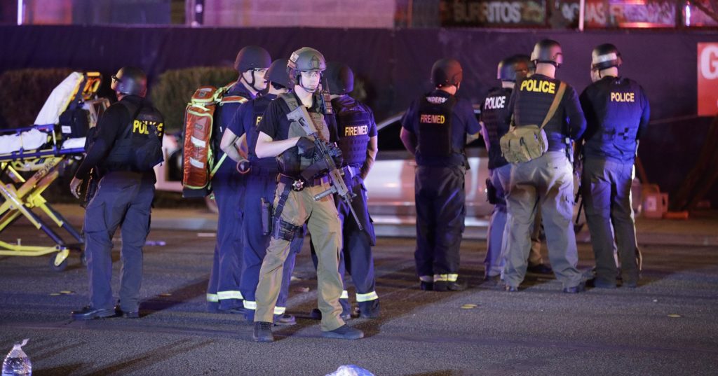 Police officers and medical personnel stand at the scene of a shooting near the Mandalay Bay resort and casino on the Las Vegas Strip, Monday, Oct. 2, 2017, in Las Vegas. Multiple victims were being transported to hospitals after a shooting late Sunday at a music festival on the Las Vegas Strip. (AP Photo/John Locher)