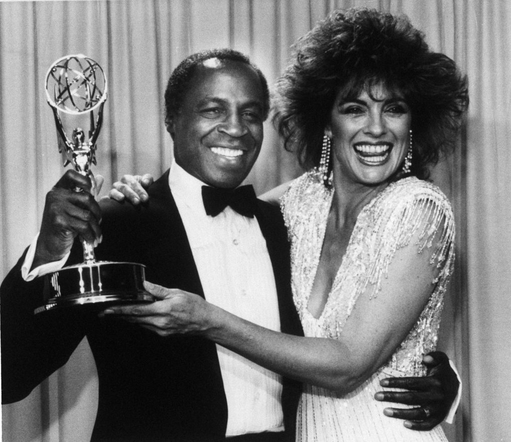 Robert Guillaume, star of "Benson", gets a hug from Linda Gray of "Dallas" who presented him with the Emmy for outstanding lead actor in a comedy series, in Pasadena, Calif., Sept. 22, 1985. (AP Photo)