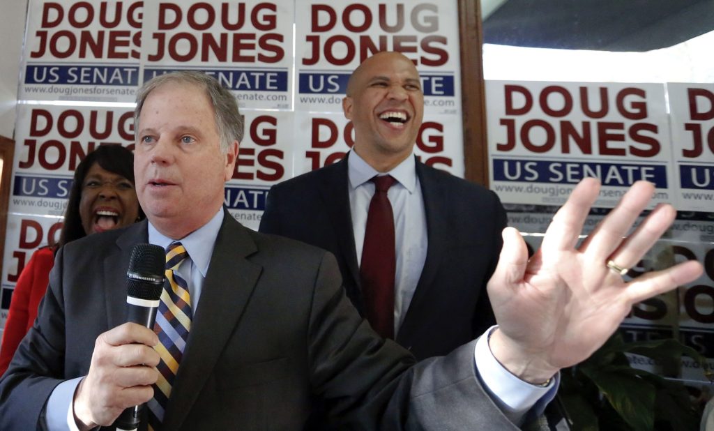 Democratic senatorial candidate Doug Jones, center, speaks during a campaign rally along side Sen. Cory Booker, D-N.J., right, and Rep. Terri Sewell, left, Sunday, Dec. 10, 2017, in Birmingham, Ala. (AP Photo/Brynn Anderson)