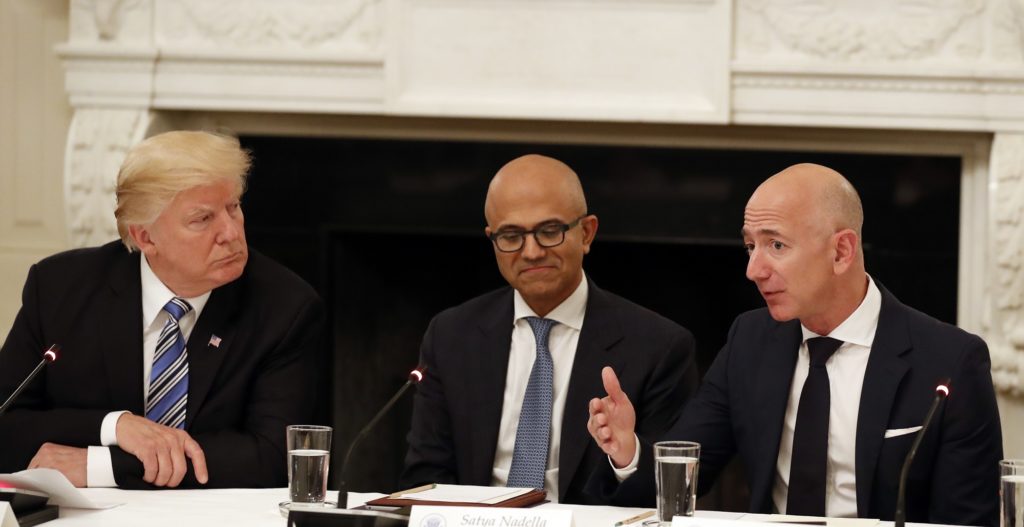 President Donald Trump, left, and Satya Nadella, Chief Executive Officer of Microsoft, center, listen as Jeff Bezos, Chief Executive Officer of Amazon, speaks during an American Technology Council roundtable in the State Dinning Room of the White House, Monday, June 19, 2017, in Washington. (AP Photo/Alex Brandon)