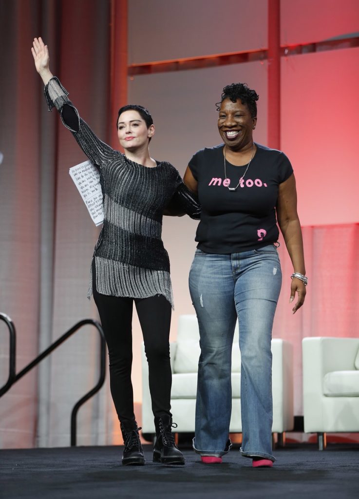 Actress Rose McGowan, left, waves after being introduced by Tarana Burke, right, founder, #MeToo Campaign, at the inaugural Women's Convention in Detroit, Friday, Oct. 27, 2017. McGowan recently went public with her allegation that film company co-founder Harvey Weinstein raped her. (AP Photo/Paul Sancya)