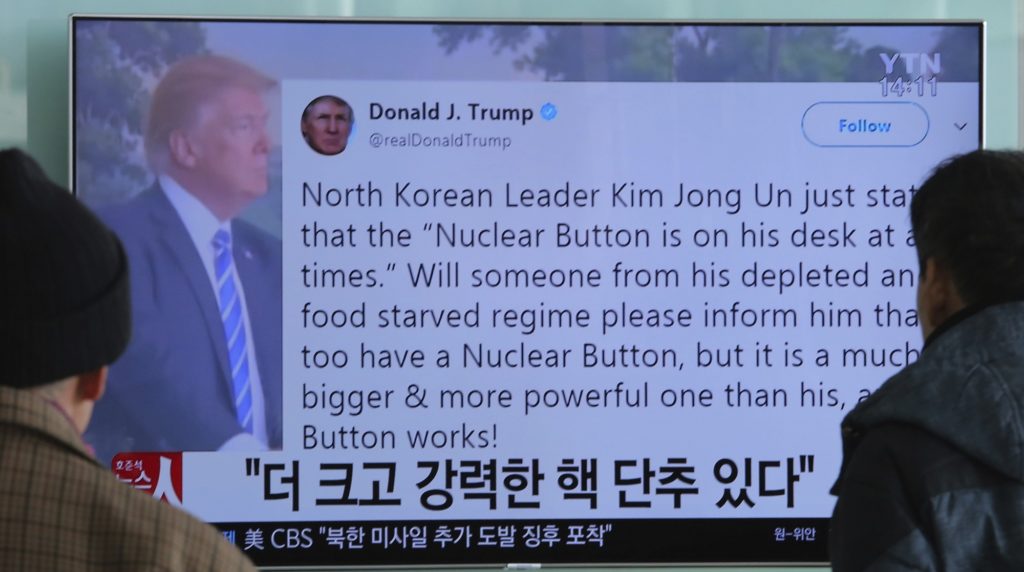 People watch a TV news program showing the Twitter post of U.S. President Donald Trump while reporting North Korea's nuclear issue, at Seoul Railway Station in Seoul, South Korea, Wednesday, Jan. 3, 2018. Trump boasted that he has a bigger and more powerful "nuclear button" than North Korean leader Kim Jong Un does — but the president doesn't actually have a physical button. The letters on the screen read: "More powerful nuclear button." (AP Photo/Ahn Young-joon)