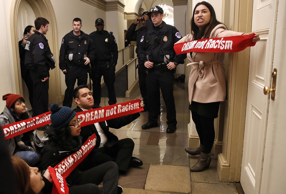 FILE - In this Thursday, Jan. 18, 2018, file photo, Diana Colin, right, with the Coalition for Humane Immigrant Rights shouts as the group from California protests outside the office of House Majority Leader Kevin McCarthy, of California, on Capitol Hill in Washington, in favor of the Deferred Action for Childhood Arrivals (DACA) program. On Monday, Feb. 26, 2018, a federal judge issued a sweeping ban on the U.S. government revoking deportation protection of immigrants brought to the United States illegally as children. (AP Photo/Jacquelyn Martin, File)