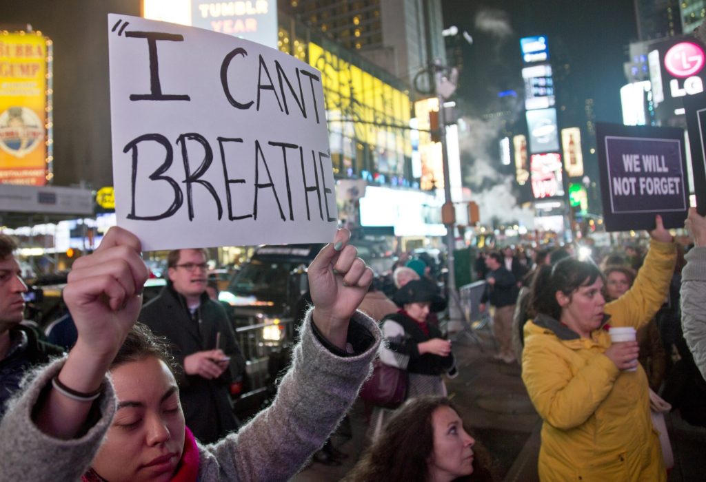 Protesters in Times Square carry signs in reaction to a non indictment against a police officer in the death of Eric Garner, Wednesday Dec. 3, 2014 in New York.  (AP Photo/Bebeto Matthews)