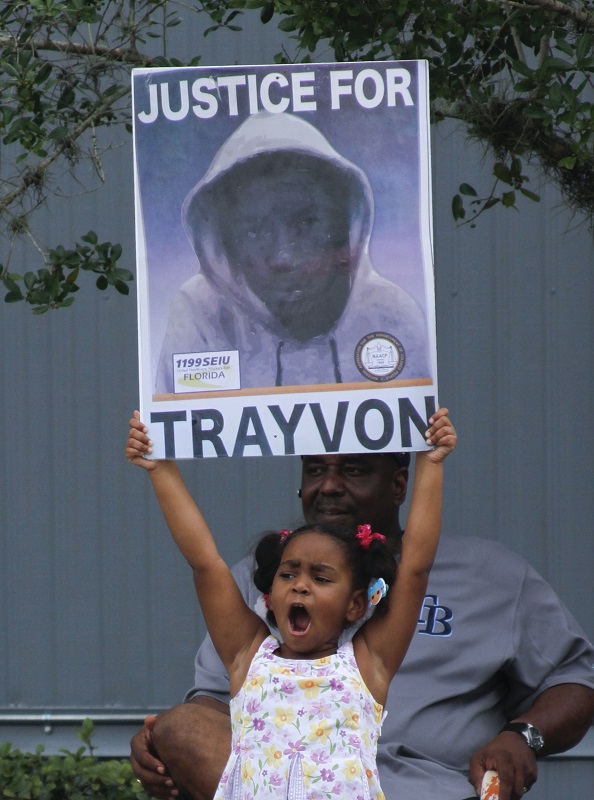 Hanna Brianna, 5, holds a sign in front of her home in the Goldsboro Historical neighborhood, Saturday, July 13, 2013, in Sanford, Fla. while residents wait for word on the verdict in the George Zimmerman trial. Zimmerman is charged with the 2012 shooting death of Trayvon Martin. (AP Photo/Mike Brown)