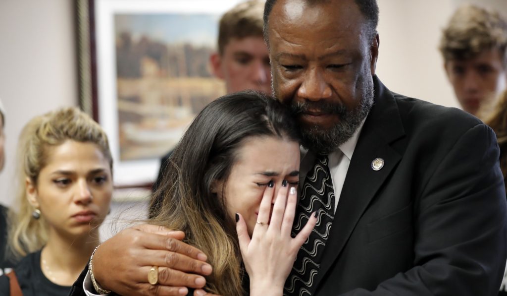 Aria Siccone, 14, a 9th grade student survivor from Marjory Stoneman Douglas High School, where more than a dozen students and faculty were killed in a mass shooting on Wednesday, cries as she recounts her story from that day, while state Rep. Barrinton Russell, D-Dist. 95, comforts her, as they talk to legislators at the state Capitol regarding gun control legislation, in Tallahassee, Fla., Wednesday, Feb. 21, 2018. (AP Photo/Gerald Herbert)