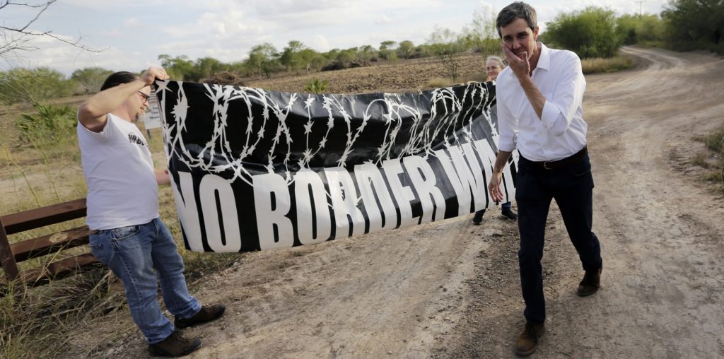 ** Hold for Story by Will Weissert Slugged Betos Battle** In this Saturday, Jan. 6, 2018, photo, Democratic Congressman Beto O'Rourke, right, passes a "No Border Wall" sign during a visit to the National Butterfly Center in Mission, Texas, a possible location for a border wall. O'Rourke is running against well-funded incumbent Republican Sen. Ted Cruz in deep-red Texas, where a Democrat hasn't captured statewide office since 1994. (AP Photo/Eric Gay)