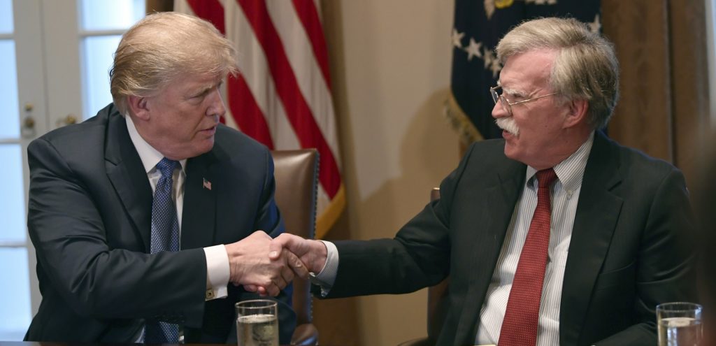 President Donald Trump, left, shakes hands with national security adviser John Bolton in the Cabinet Room of the White House in Washington, Monday, April 9, 2018, at the start of a meeting with military leaders. (AP Photo/Susan Walsh)