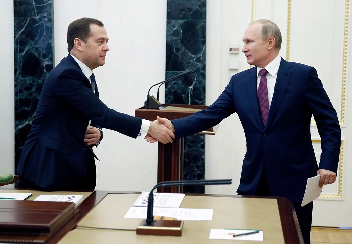 Russian President Vladimir Putin, right, shakes hands with Russian Prime Minister Dmitry Medvedev as he arrives to attend a Security Council meeting in Moscow, Russia, Friday, April 6, 2018. The meeting focused on border protection. (Dmitry Astakhov, Sputnik, Government Pool Photo via AP)