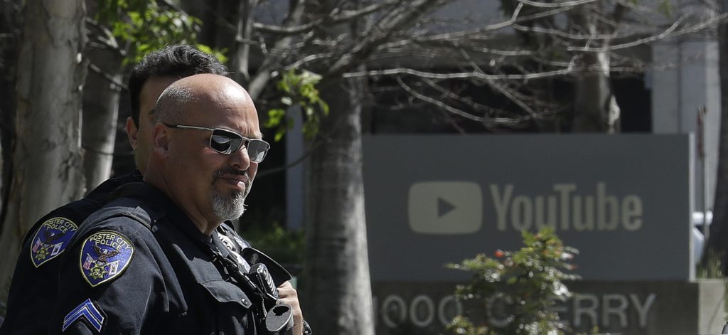 Officers stand in front of a YouTube sign near offices in San Bruno, Calif., Tuesday, April 3, 2018. A woman opened fire at YouTube headquarters Tuesday, setting off a panic among employees and wounding several people before fatally shooting herself, police and witnesses said. (AP Photo/Jeff Chiu)
