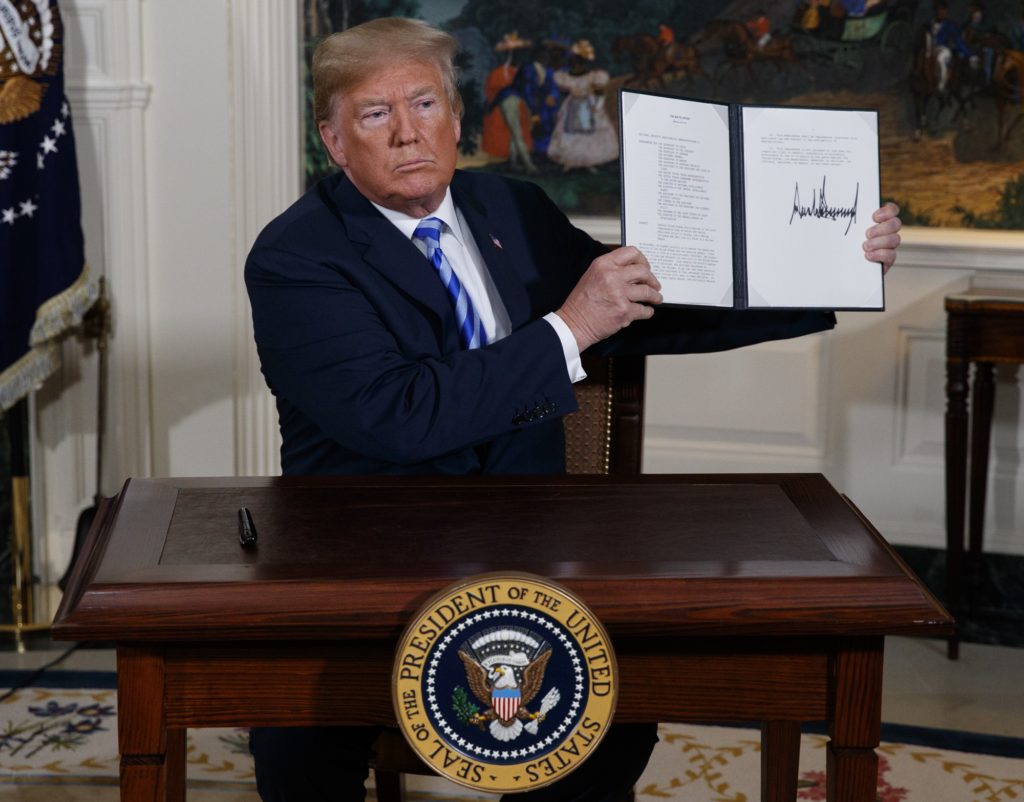 President Donald Trump signs a Presidential Memorandum on the Iran nuclear deal from the Diplomatic Reception Room of the White House, Tuesday, May 8, 2018, in Washington. (AP Photo/Evan Vucci)