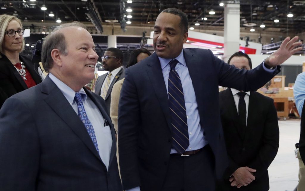 Ron Stallworth of Fiat Chrysler Automobiles, right, shows Detroit Mayor Mike Duggan around the company's show space at the North American International Auto Show, Monday, Jan. 8, 2018, in Detroit. (AP Photo/Carlos Osorio)