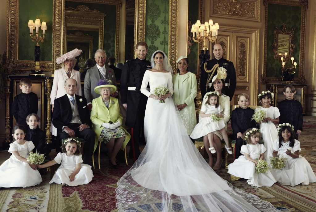 In this photo released by Kensington Palace on Monday May 21, 2018, shows an official wedding photo of Britain's Prince Harry and Meghan Markle, center, in Windsor Castle, Windsor, England, Saturday May 19, 2018. Others in photo from left, back row, Jasper Dyer, Camilla, Duchess of Cornwall, Prince Charles, Doria Ragland, Prince William; center row, Brian Mulroney, Prince Philip, Queen Elizabeth II, Kate, Duchess of Cambridge, Princess Charlotte, Prince George, Rylan Litt, John Mulroney; front row, Ivy Mulroney, Florence van Cutsem, Zalie Warren, Remi Litt. (Alexi Lubomirski/Kensington Palace via AP)