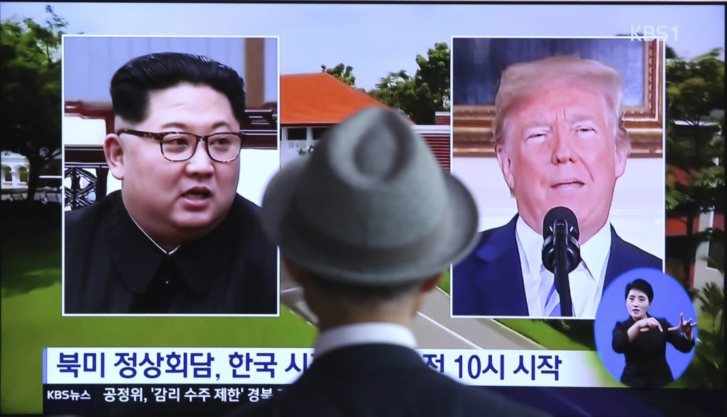 A man watches a TV screen showing file footage of U.S. President Donald Trump, right, and North Korean leader Kim Jong Un during a news program at the Seoul Railway Station in Seoul, South Korea, Monday, June 11, 2018.  Final preparations are underway in Singapore for Tuesday's historic summit between President Trump and North Korean leader Kim, including a plan for the leaders to kick things off by meeting with only their translators present, a U.S. official said.  The signs read: " Summit between the United States and North Korea." (AP Photo/Ahn Young-joon)