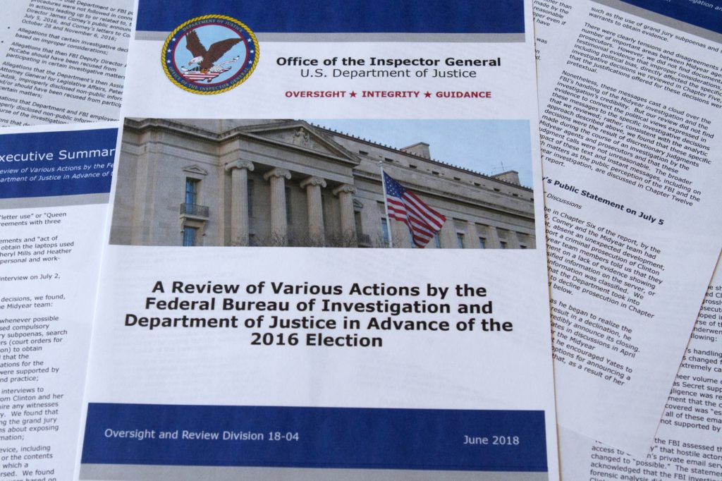 Part of the the Department of Justice Inspector General's report after its release in Washington, Thursday, June 14, 2018. The report documented in painstaking detail one of the most consequential investigations in modern FBI history and revealed how the bureau, which for decades has endeavored to stand apart from politics, came to be entangled in the 2016 presidential election.(AP Photo/Jon Elswick)