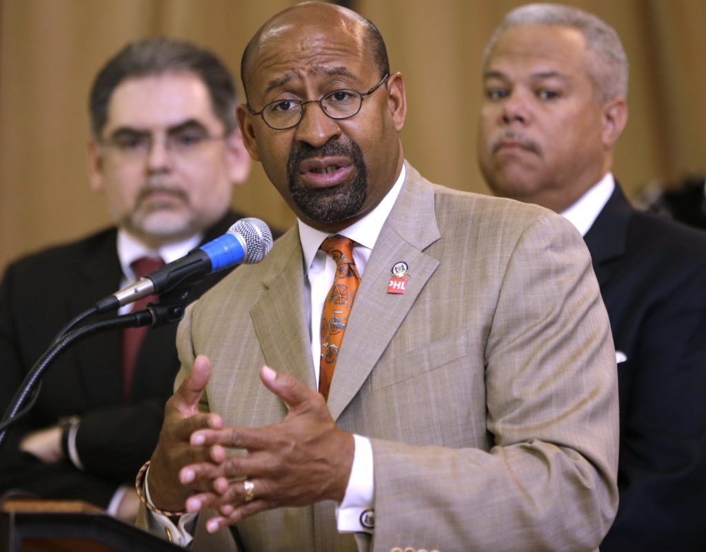 Mayor Michael Nutter, accompanied by Pedro A. Ramos, Chairman, School Reform Commission, left, and state Sen. Anthony Williams D-Philadelphia, speaks during a news conference at Andrew Jackson Public School, Thursday, May 9, 2013, in Philadelphia. After days of protests and walkouts by city students concerned about budget cuts, local officials called for additional funds for the Philadelphia school district. The system is facing a $300 million deficit, which education advocates say will devastate classrooms. (AP Photo/Matt Rourke)