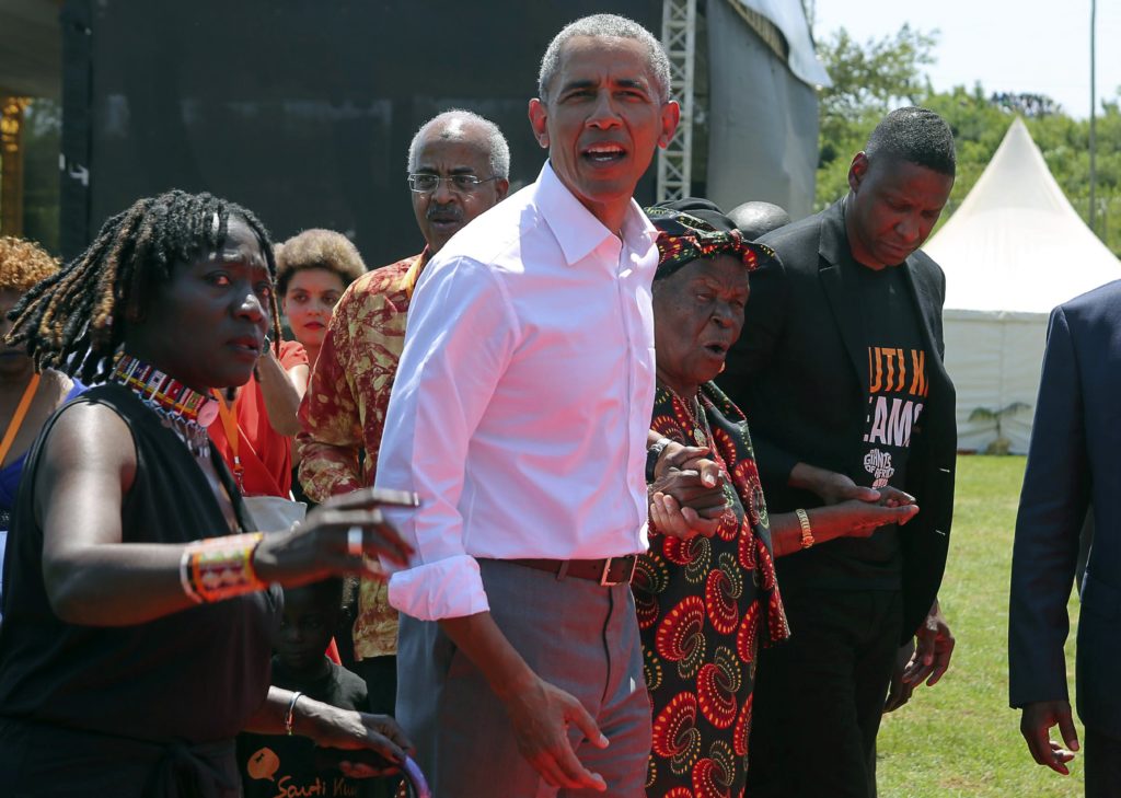 Former US President Barack Obama, center, with his half sister Auma Obama, left, and her grandmother, Sarah Obama, second right walk in Kogelo, Kenya, Monday, July 16, 2018. Former U.S. President Barack Obama Monday praised Kenya's president and opposition leader for working together but said this East African country must do more to end corruption. Obama, on his first visit to Africa since stepping down as president, commended President Uhuru Kenyatta and opposition leader Raila Odinga for cooperating following last year's disputed presidential election which were marked by violence.(AP Photo Brian Inganga)