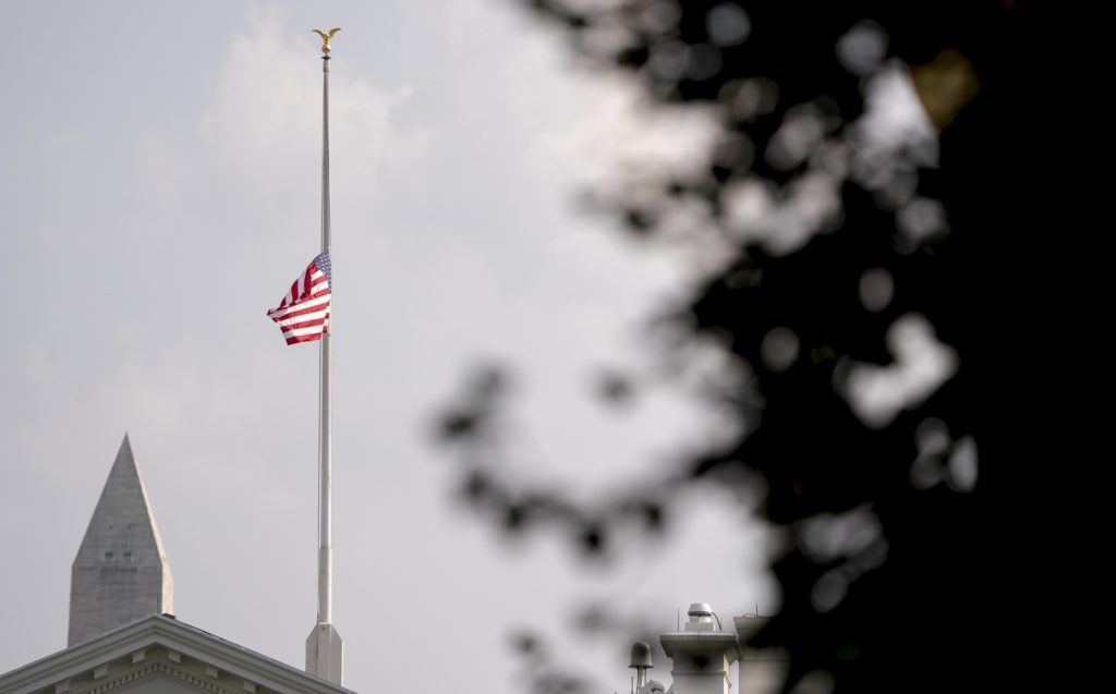 The American flag files at half-staff at the White House, Monday afternoon, Aug. 27, 2018, in Washington. Two days after Sen. John McCain's death, President Donald Trump says he respects the senator's "service to our country" and has signed a proclamation to fly the U.S. flag at half-staff until his burial. The flag atop the White House flew at half-staff over the weekend but was raised Monday and then lowered again amid criticism. (AP Photo/Andrew Harnik)