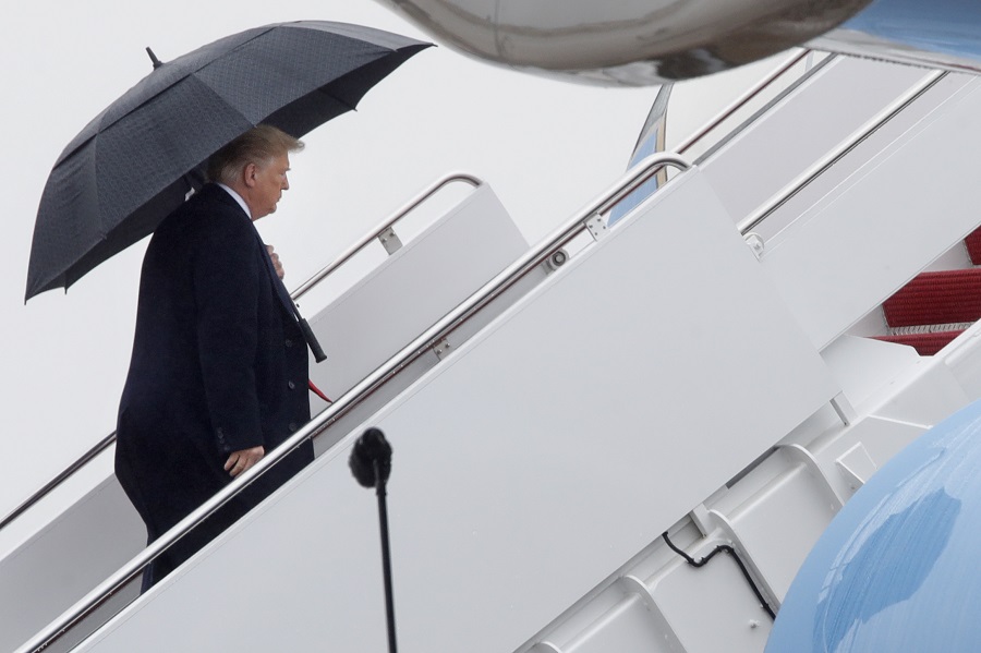 President Donald Trump holds an umbrella as he walks up the stairs of Air Force One after speaking to the media under the wing about the shootings at a synagogue in Pittsburgh, Saturday, Oct. 27, 2018, from Andrews Air Force Base, Md., en route to Indianapolis. (AP Photo/Jacquelyn Martin)