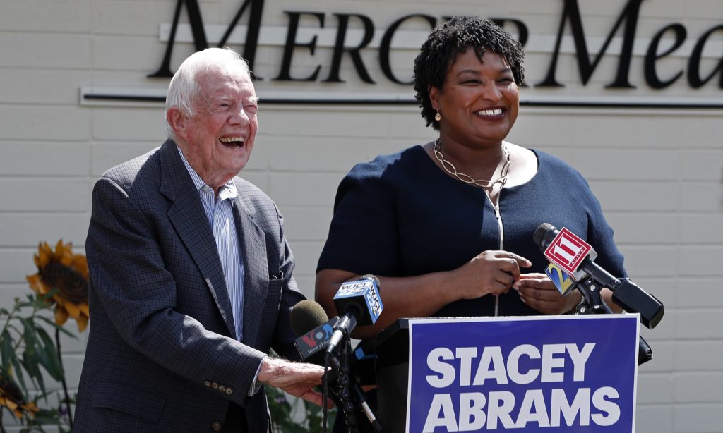 Former President Jimmy Carter and Democratic gubernatorial candidate Stacey Abrams speak to reporters during a news conference to announce her rural health care plan Tuesday, Sept. 18, 2018, in Plains, Ga. (AP Photo/John Bazemore)