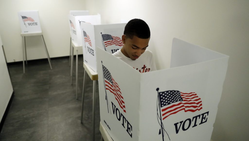 Christian Goodman, 18, votes for the first time in his life at the Los Angeles County Registrar of Voters office Tuesday, Oct. 23, 2018, in Norwalk, Calif. The general election takes place on Nov. 6th. (AP Photo/Marcio Jose Sanchez)