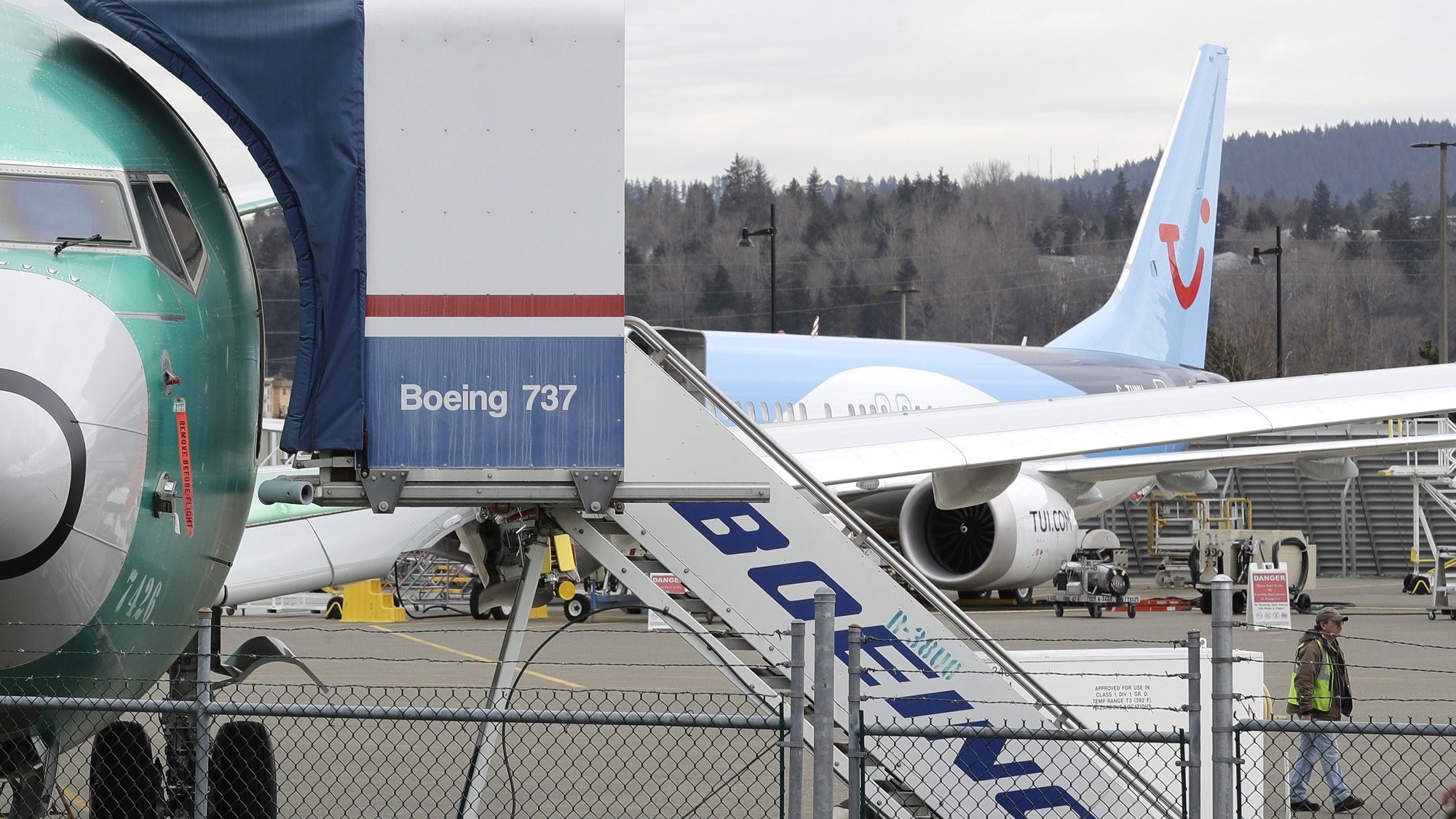 In this photo taken Monday, March 11, 2019, a Boeing 737 MAX 8 airplane being built for TUI Group sits parked in the background at right at Boeing Co.'s Renton Assembly Plant in Renton, Wash. Britain, France and Germany on Tuesday joined a rapidly growing number of countries grounding the new Boeing plane involved in the Ethiopian Airlines disaster or turning it back from their airspace, while investigators in Ethiopia looked for parallels with a similar crash just five months ago.  (AP Photo/Ted S. Warren)