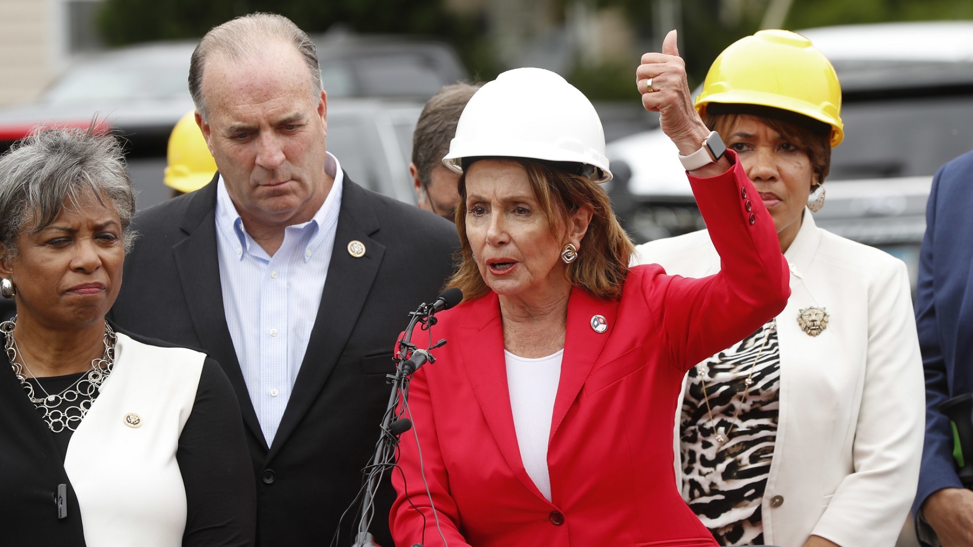 House Minority Leader Nancy Pelosi of Calif. speaks as Rep. Brenda Lawrence, D-Mich., from left, Rep. Daniel Kildee, D-Mich., and Mayor Karen Weaver listens during a congressional delegation visit to receive an update on the water crisis and observe lead pipe replacement in Flint, Mich., Friday, July 20, 2018. (AP Photo/Paul Sancya)