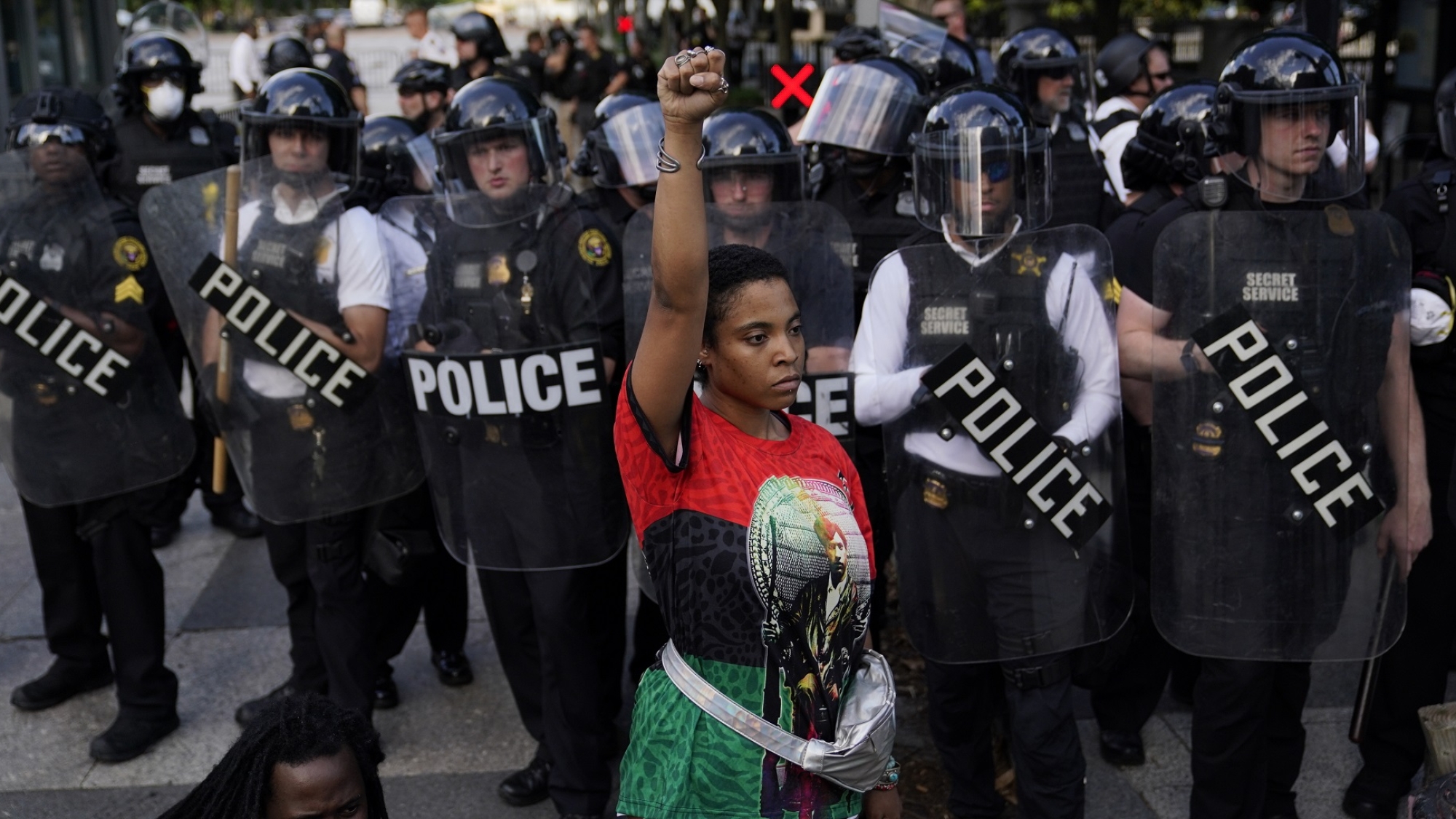 A demonstrator raises their fist as others gather to protest the death of George Floyd, Saturday, May 30, 2020, near the White House in Washington. Floyd died after being restrained by Minneapolis police officers. (AP Photo/Evan Vucci)