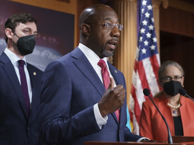 Sen. Raphael Warnock, D-Ga., flanked by Sen. Jon Ossoff, D-Ga., left, and Rep. Carolyn Bourdeaux, D-Ga., tells reporters they want to include specific provisions of their legislation, the Medicaid Saves Lives Act, in the larger economic package known as the Build Back Better Act to address the Medicaid coverage gap and provide an immediate fix to close the gap in Georgia and several other states, at the Capitol in Washington, Thursday, Sept. 23, 2021. (AP Photo/J. Scott Applewhite)