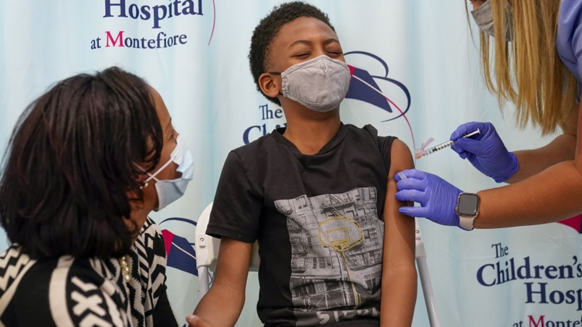 Dr. Rhonda Achonolu comforts her son Kenechi, 9, as he is inoculated with first dose of the Pfizer-BioNTech COVID-19 vaccine for children five to 12 years at The Children's Hospital at Montefiore, Wednesday, Nov. 3, 2021, in the Bronx borough of New York. The U.S. enters a new phase Wednesday in its COVID-19 vaccination campaign, with shots now available to millions of elementary-age children in what health officials hailed as a major breakthrough after more than 18 months of illness, hospitalizations, deaths and disrupted education. (AP Photo/Mary Altaffer)