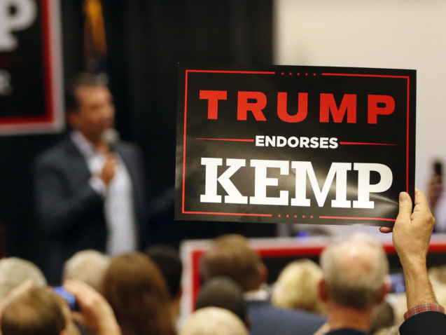 A man holds a sign as Donald Trump Jr., speaks during a campaign event of Republican nominee for Georgia Gov. Brian Kemp Tuesday, Oct. 9, 2018, in Athens, Ga. (AP Photo/John Bazemore)