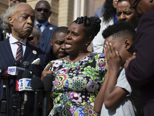 RETRANMISSION TO CORRECT NAME TO JAQUES “JAKE” PATTERSON - Tirzah Patterson, former wife of Buffalo shooting victim Heyward Patterson, speaks as her son, Jaques "Jake" Patterson, 12, covers his face during a press conference outside the Antioch Baptist Church on Thursday, May 19, 2022, in Buffalo, N.Y. (AP Photo/Joshua Bessex)