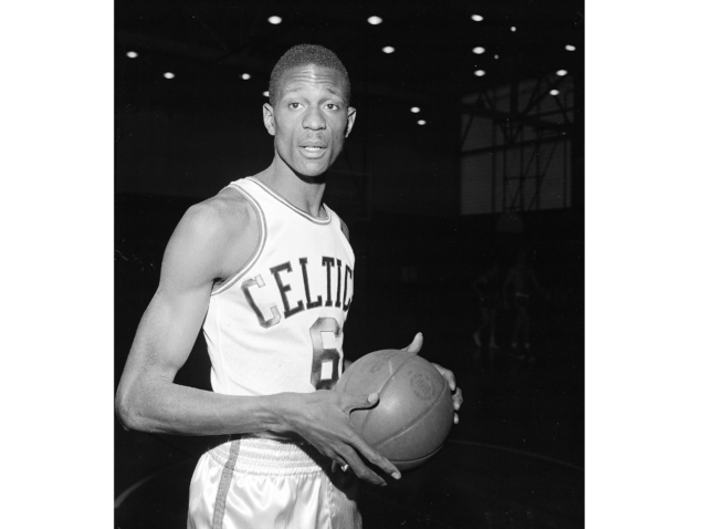 FILE - Bill Russell, of San Francisco, wears a Boston Celtics uniform for his first workout with the NBA team shortly after having signed a contract in Boston on Dec. 19, 1956.  The NBA great Bill Russell has died at age 88. His family said on social media that Russell died on Sunday, July 31, 2022. Russell anchored a Boston Celtics dynasty that won 11 titles in 13 years. (AP Photo)