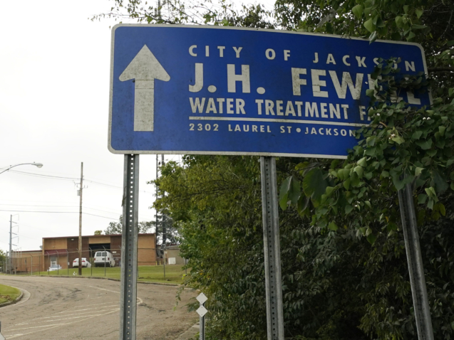 A sign marks the road leading to the City of Jackson, Miss., J.H. Fewell Water Treatment Plant at the edge of the historic Belhaven neighborhood, Wednesday, Oct. 20, 2021. Two new lawsuits filed Tuesday, Oct. 19, claim hundreds of children have been exposed to dangerous lead levels through the drinking water in Mississippi's capital city, which has been facing water system problems for years. (AP Photo/Rogelio V. Solis)