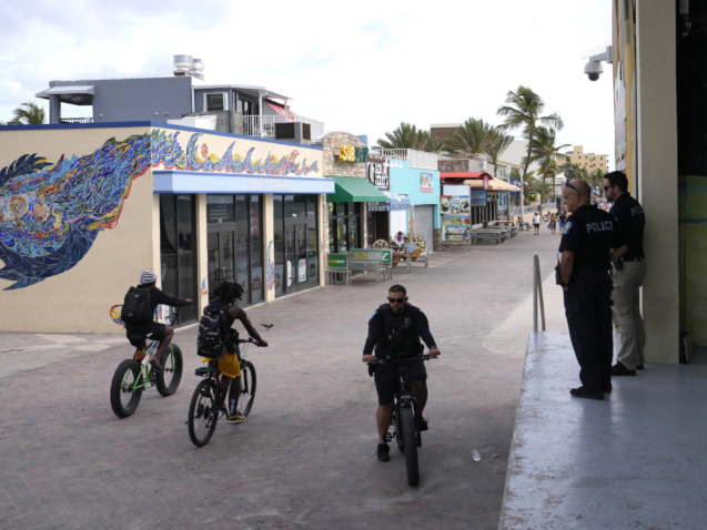 Hollywood police patrol near the scene of a shooting along the Hollywood Broadwalk, Tuesday, May 30, 2023, in Hollywood, Fla. Nine people were injured when gunfire erupted along the beachside promenade, sending people running for cover along the crowded beach on Memorial Day. (AP Photo/Lynne Sladky)