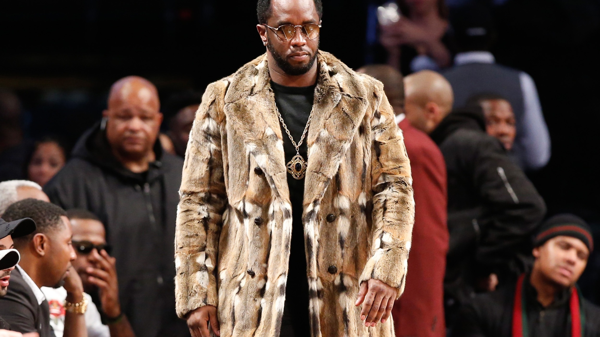 FILE - Sean "Diddy" Combs, wearing a fur coat, walks down the sideline during the second half of an NBA basketball game between the Brooklyn Nets and the New York Knicks, Sunday, March 12, 2017, in New York. Combs' lawyer said Tuesday, March 26, 2024, that the searches of his Los Angeles and Miami properties by federal authorities in a sex-trafficking investigation were ”a gross use of military-level force" and that Combs is “innocent and will continue to fight" to clear his name.  (AP Photo/Kathy Willens, File)