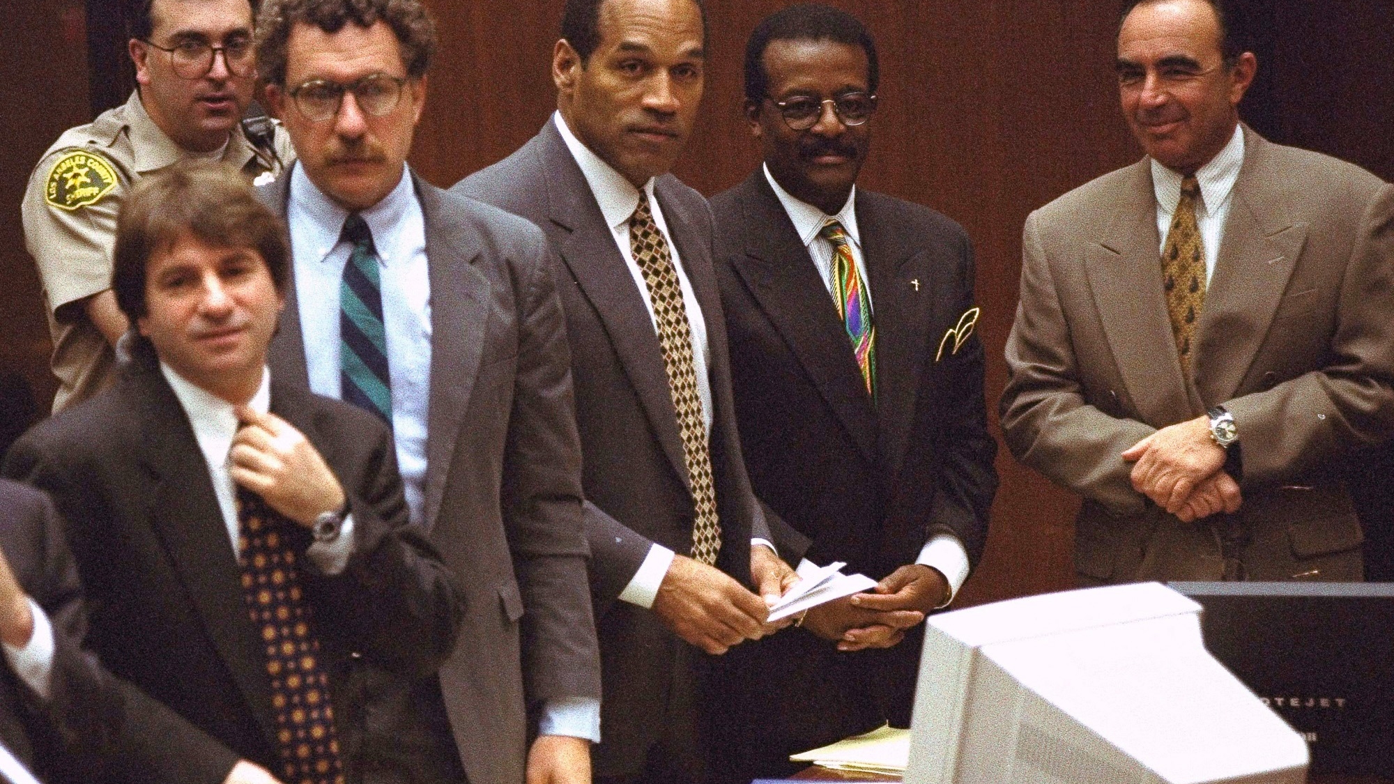 FILE -  Defendant O.J. Simpson and members of his defense team react as the jury, many wearing white T-shirts sporting a slogan from a local pizza chain, walk into the courtroom in Los Angeles Friday, May 5, 1995. From left to right are" Barry Scheck, Peter Neufeld, O.J. Simpson, Johnnie Cochran Jr., and Robert Shapiro. Background is Deputy Guy Magnera. Simpson, the decorated football superstar and Hollywood actor who was acquitted of charges he killed his former wife and her friend but later found liable in a separate civil trial, has died. He was 76. (AP Photo/Reed Saxon, Pool, File)